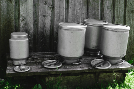 Few drying washed metal milk canisters, churns in the countrysideの写真素材