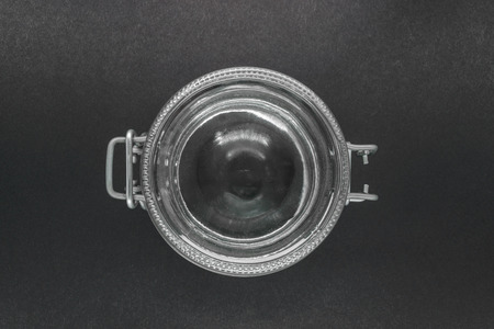 View from top of closed glass jar with metal holder on black background surfaceの写真素材