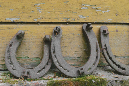 Background surface of very old and rusty horseshoes placed near the wallの写真素材