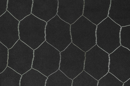 Hexagon shape metal fence on black background surface