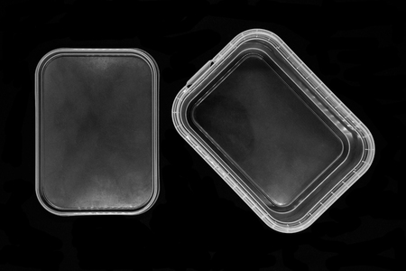 Transparent plastic box bottom separated from lid and isolated on black background surfaceの写真素材
