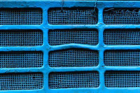 Background surface of blue, dirty and damaged metallic gridの写真素材
