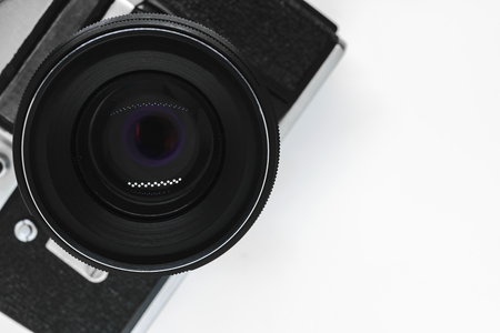 Very old vintage SLR black photo camera with black lens view from top with copy space and white backgroundの写真素材