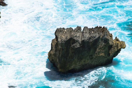 Landscape of blue Indian ocean washing and huge rock