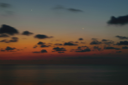 Beautiful sunset in Bali island with visible smiling moon and north starの写真素材