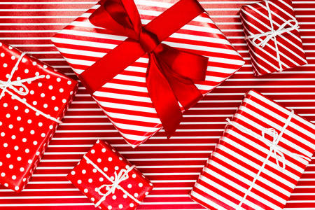 Various size wrapped in red paper with ornament Christmas gift boxes on red with white lines backgroundの写真素材