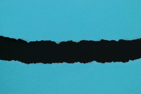 Blue ripped paper placed on black background paper with copy spaceの写真素材