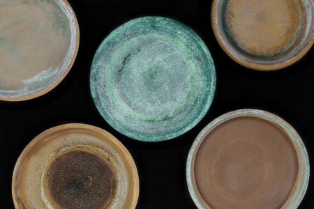 Background surface of various colors and dirty clay plates for plants and isolated on black backgroundの写真素材