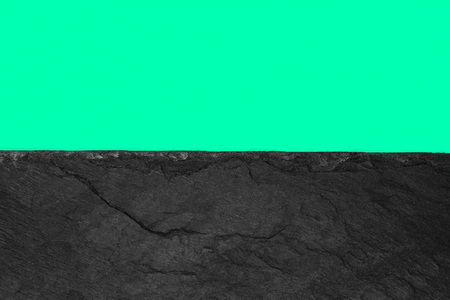Abstract background composition of divided in the half vivid soft green color paper and black stone with copy spaceの写真素材