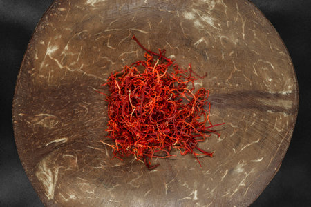 Saffron in natural coconut brown bowl on black background