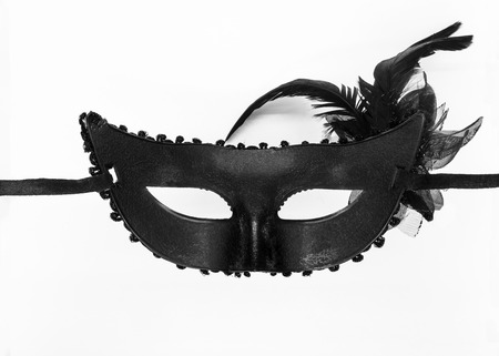 Inner side of black carnival mask with attached artificial black and brown bouquet on white backgroundの写真素材