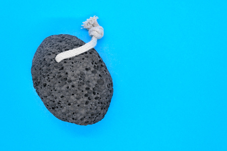 Black pumice stone with white rope for spa on blue background with copy spaceの写真素材