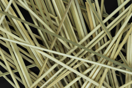 Messy looking background of natural bamboo skewers which are used for cooking on black background