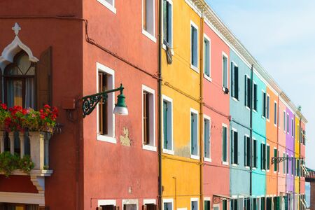 Colorful houses in Burano island during hot summer and sunny evening, Veniceの写真素材