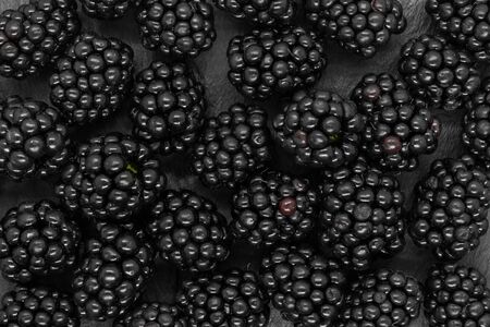 Background of blackberries on black stone background surfaceの写真素材