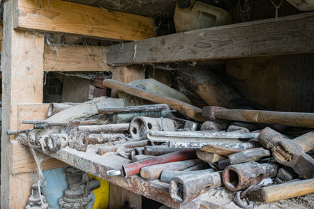 Wooden, dusty and full of spider webs rural shelf with a lot of rural metal working tools