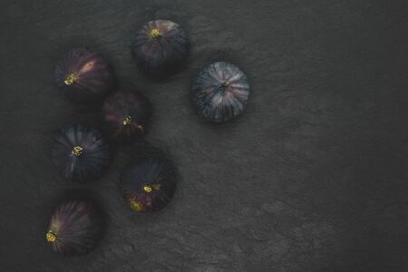 Top view of ripe purple common fig (Ficus carica) fruits on black stone backgroundの写真素材