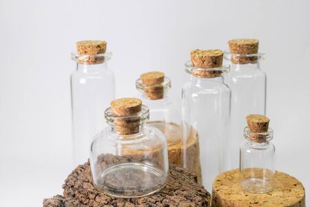 Various glass bottles with cork lids in white background and placed on the corksの写真素材
