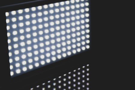Many LED lights covered with scratched transparent matte filter reflect the light on black background with copy spaceの写真素材