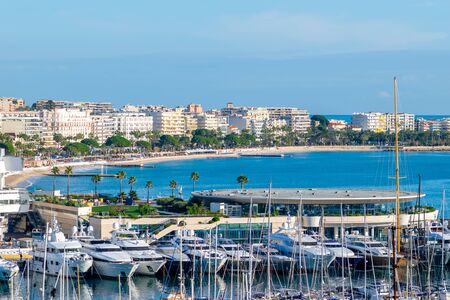 Cannes city coast with yachts, hotels and palm trees during clear and sunny day with copy spaceの写真素材