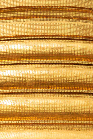 Abstract background of shiny golden mosaic bell sculpture circles in Thailand temple illuminated by...
