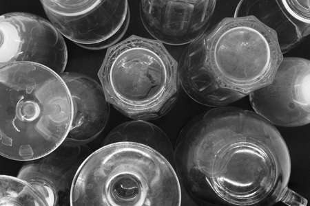 Top view of various dirty and with lime dots drinking glasses placed upside down on black matte backgroundの写真素材