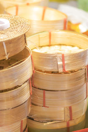 Stack of wooden bamboo bowls for food in Thailand fresh food market market. Image is soft with noise and grains. Image with shallow depth of fieldの写真素材