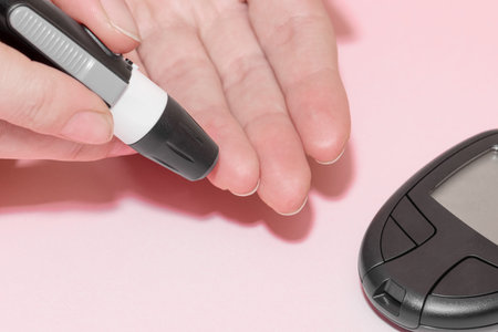 Health care concept. Close-up view of woman fingers doing blood test for sugar level (glucose) with...