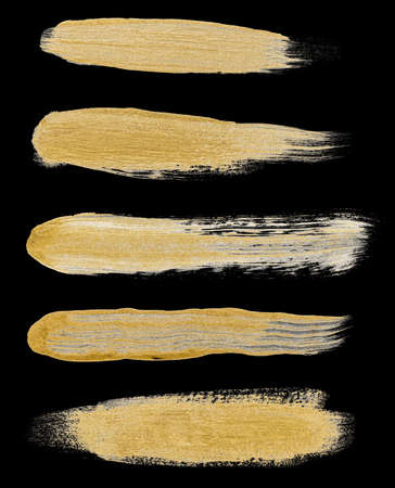Collection of various hand drawing golden paint brush strokes isolated on black backgroundの写真素材
