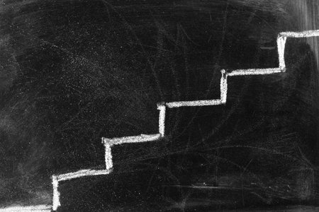 White chalk drawing of stairs on black grunge background