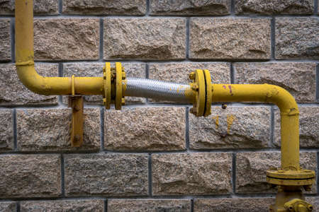 Yellow natural gas pipe on the wallの写真素材