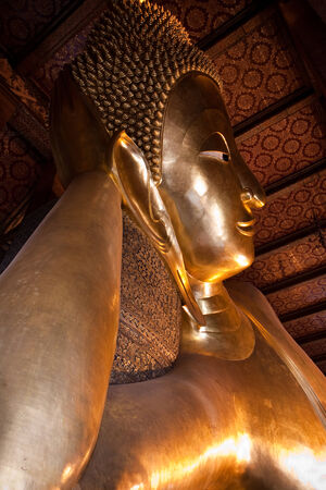 Reclining buddha in Wat Pho with half view of Bangkok, Thailandのeditorial素材