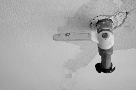 Old water valve on wall in black and whiteの写真素材