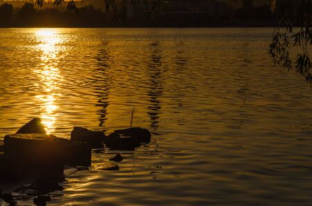 Beautiful sunset over the river. The solar path on the surface of the water. Reflection of the setting sun.の写真素材