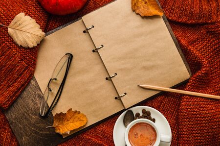 A diary, cup of coffee, fallen leaves. Plans for november. Autumn concept. Copy space. Flat lay, top viewの写真素材