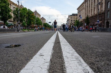 Kiev, Ukraine - July 14, 2019. Khreshchatyk st. White double dividing line. People walk on the roadway with blocked traffic.のeditorial素材