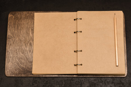 Eco friendly open notebook in wooden cover with blank sheets with space for your text and pencil on...