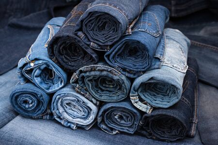 Rolled jeanses of different shades on denim background. Closeupの写真素材