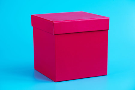 Pink gift box on blue background. Holidays concept. Closeup. Mockup