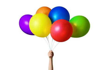 Female hand holding bunch of bright colorful balloons isolated on white background. Six multicolored balloons in LGBT flag colors. Holiday conceptの写真素材
