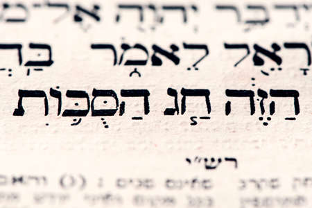 Closeup of hebrew words in Torah page that translates in english as This is the Sukkot holiday. Biblical Jewish holidays. Selective focusの写真素材