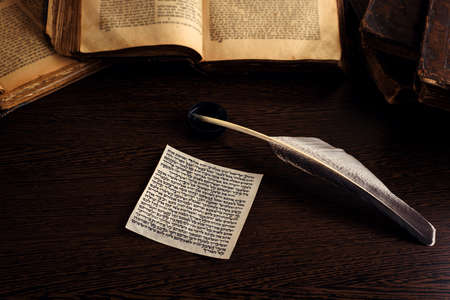 Mezuzah with Jewish prayer Shema Yisrael in hebrew, which translates into English as list of Biblical commandments, quill and open Torah in the background. Low keyの写真素材