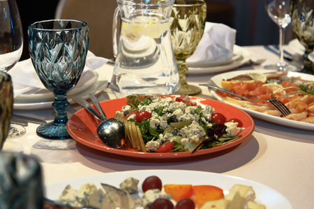 Table setting with appetizers, dishes, salads, glasses and jug of water. selective focusの写真素材