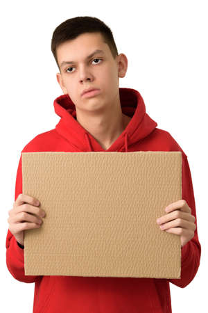 Bored exhausted teenage boy holding blank brown cardboard banner, tired of problems. Young guy with expression of indifference feeling upset. He is fed up. Half length portrait isolated on whiteの写真素材