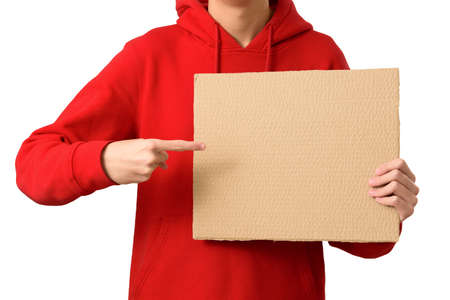 Hands of teenager holding blank brown cardboard banner and pointing index finger in copy space, isolated on white background. Job search, sale, ad promo concept. close upの写真素材