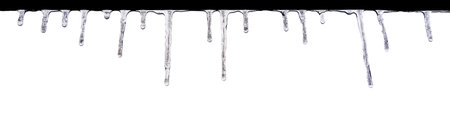Closeup of icicles hanging in a row isolated on white background. Spring thawの写真素材