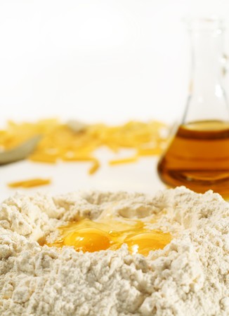 Flour Heap and Egg with Olive Oil on a Background. Focus Point on Eggの写真素材