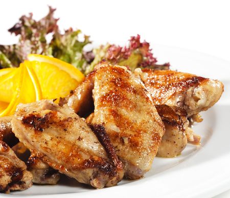 Hot Meat Dishes - Fried Chicken Wings with Orange Slice and Vegetable Leafの写真素材