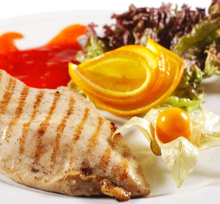 Hot Meat Dishes - Grilled Chicken Steak with Sauce and Orange Sliceの写真素材
