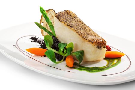 Chile Sea Bass (black sea bass) served with Black Risotto, Herbs and Vegetablesの写真素材
